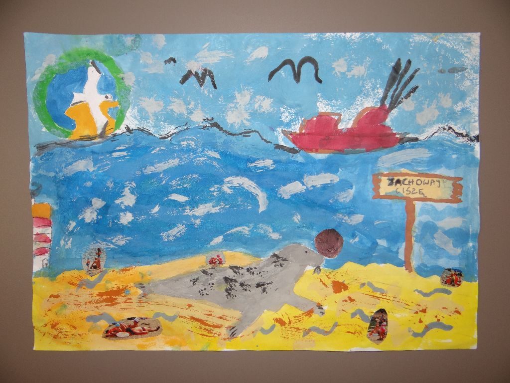 Malunek farbami plakatowymi. Na plaży odpoczywa foka, za nią na morzu płynie statek. Na tle błękitnego nieba logo Parku.